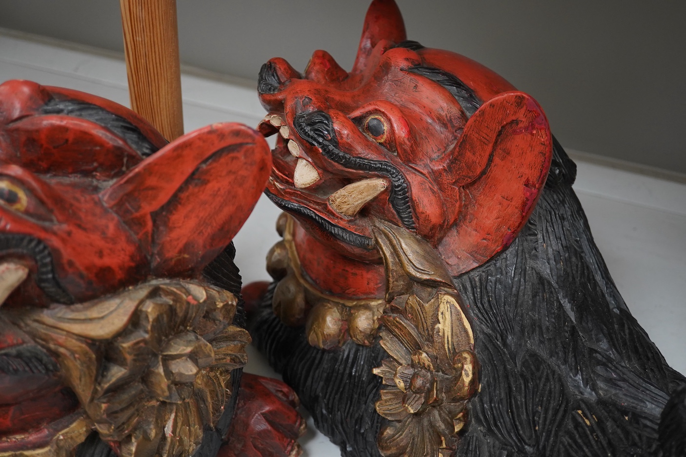 A pair of large Indonesian carved and painted wood lion dogs, 67cm wide.